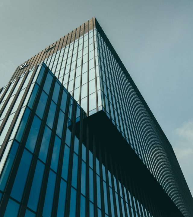 low angle shot of a building in a glass facade under the beautiful cloudy sky